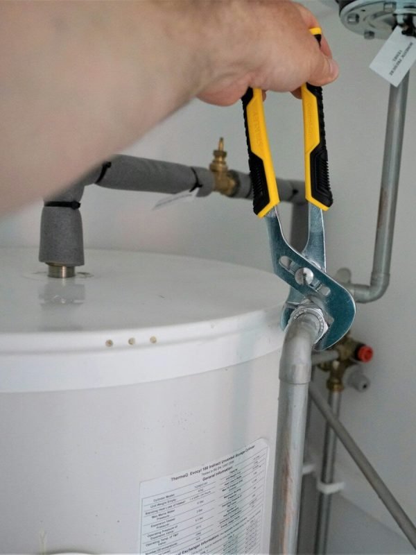 person holding yellow and gray hand tool